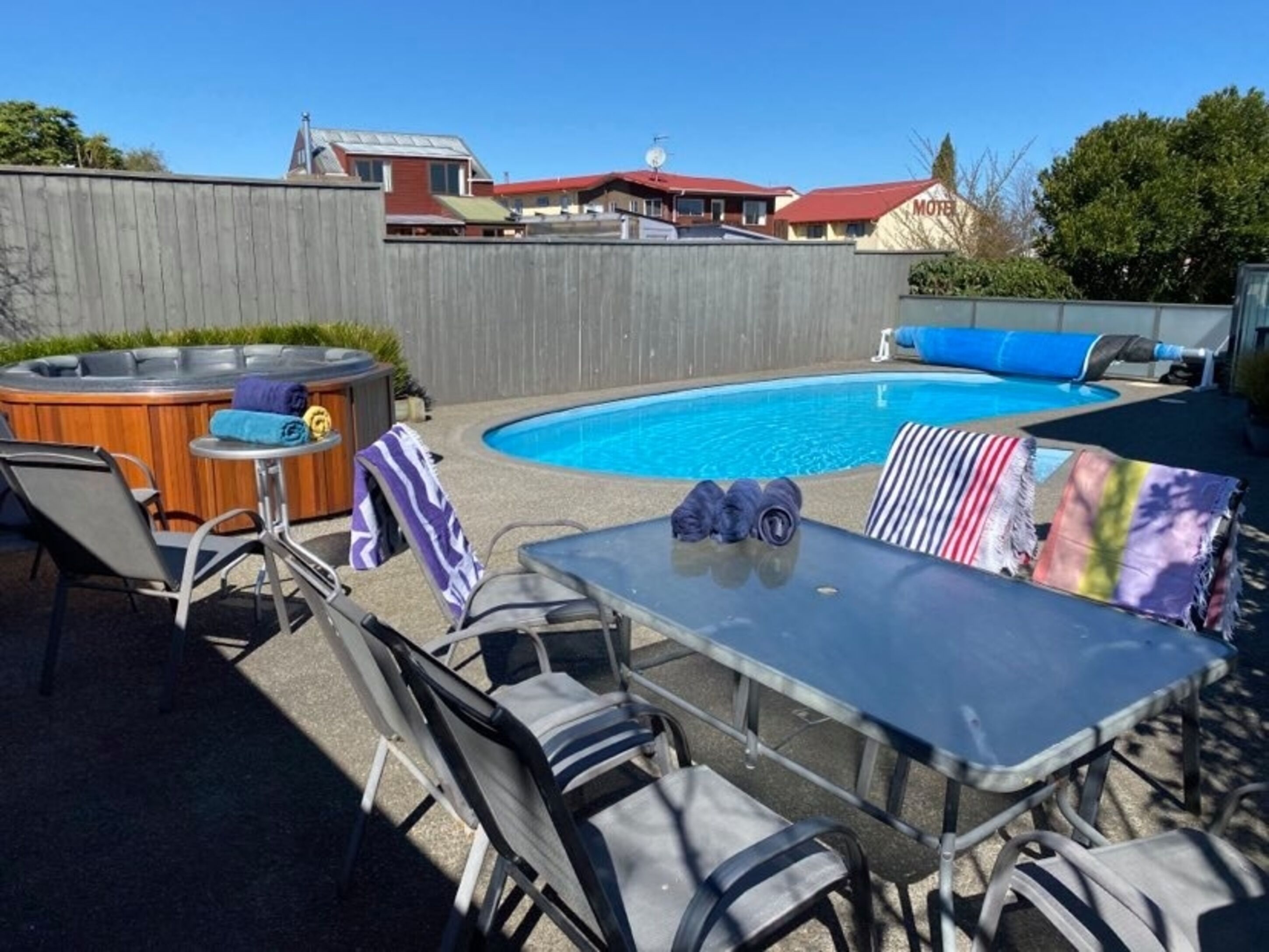 A backyard with a swimming pool, a hot tub, and outdoor seating.