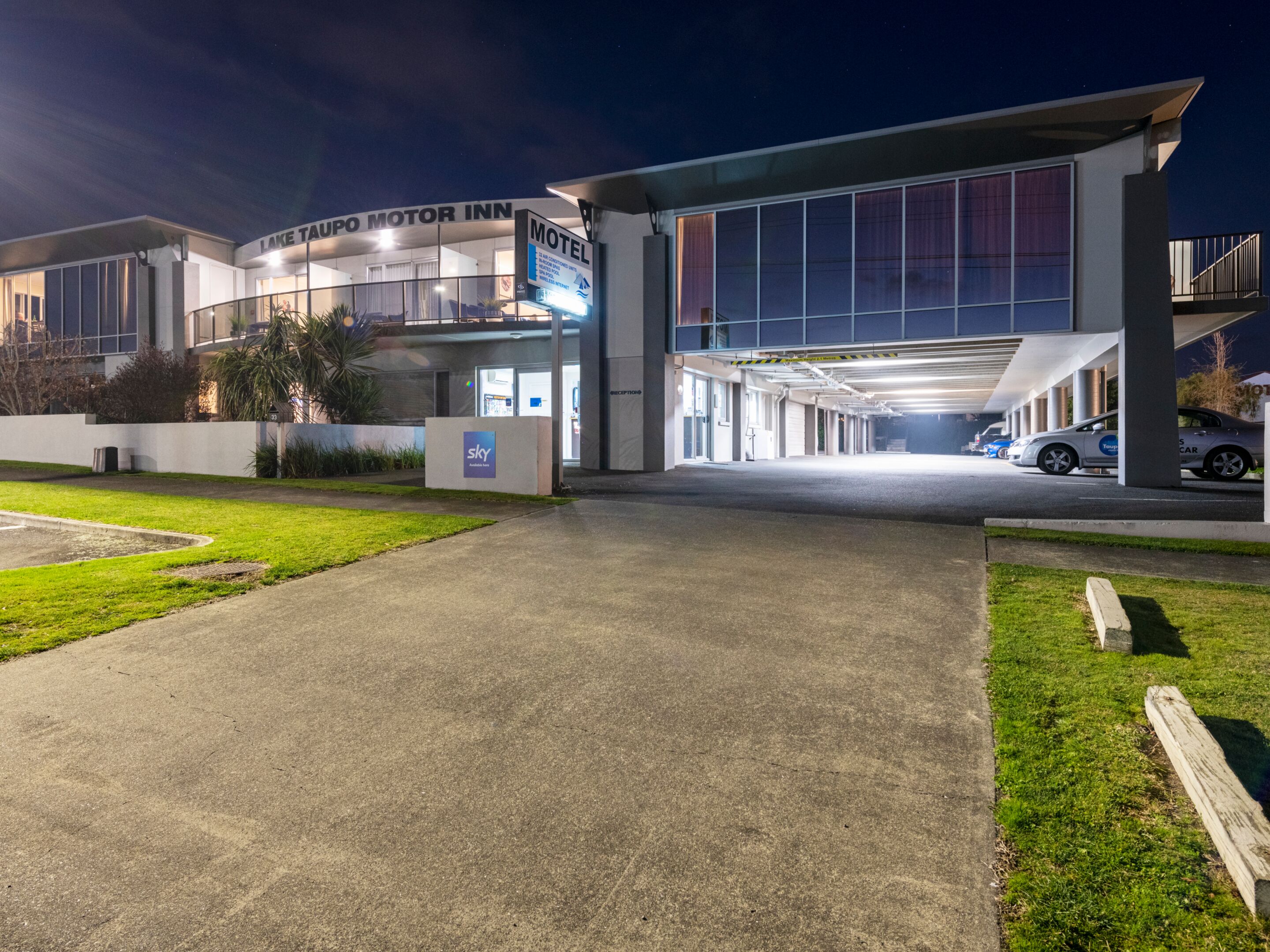 Un motel moderno con un ampio parcheggio sotterraneo e un ingresso ben illuminato.