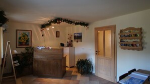 A cozy room with a wooden desk, a small kitchen area, and a bookshelf. - Apartments Bohinj na vasi (Bohinj)