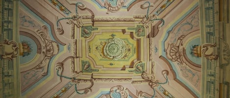 Un plafond richement décoré, orné de motifs complexes et surmonté d’un médaillon central.