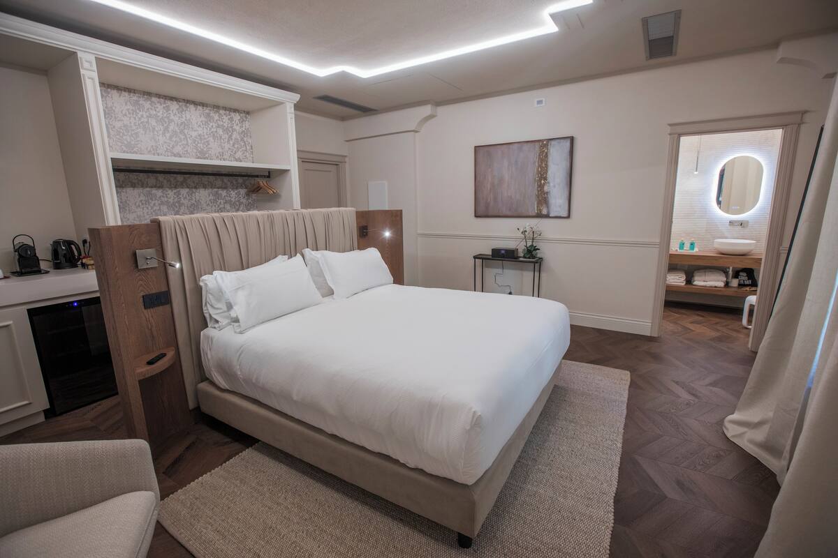 A neatly arranged bedroom with a bed, bedside table, and a built-in wardrobe.