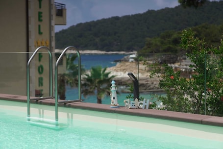 Seasonal outdoor pool, open 11:00 AM to 10:00 PM, pool umbrellas. Hotel Fortuna