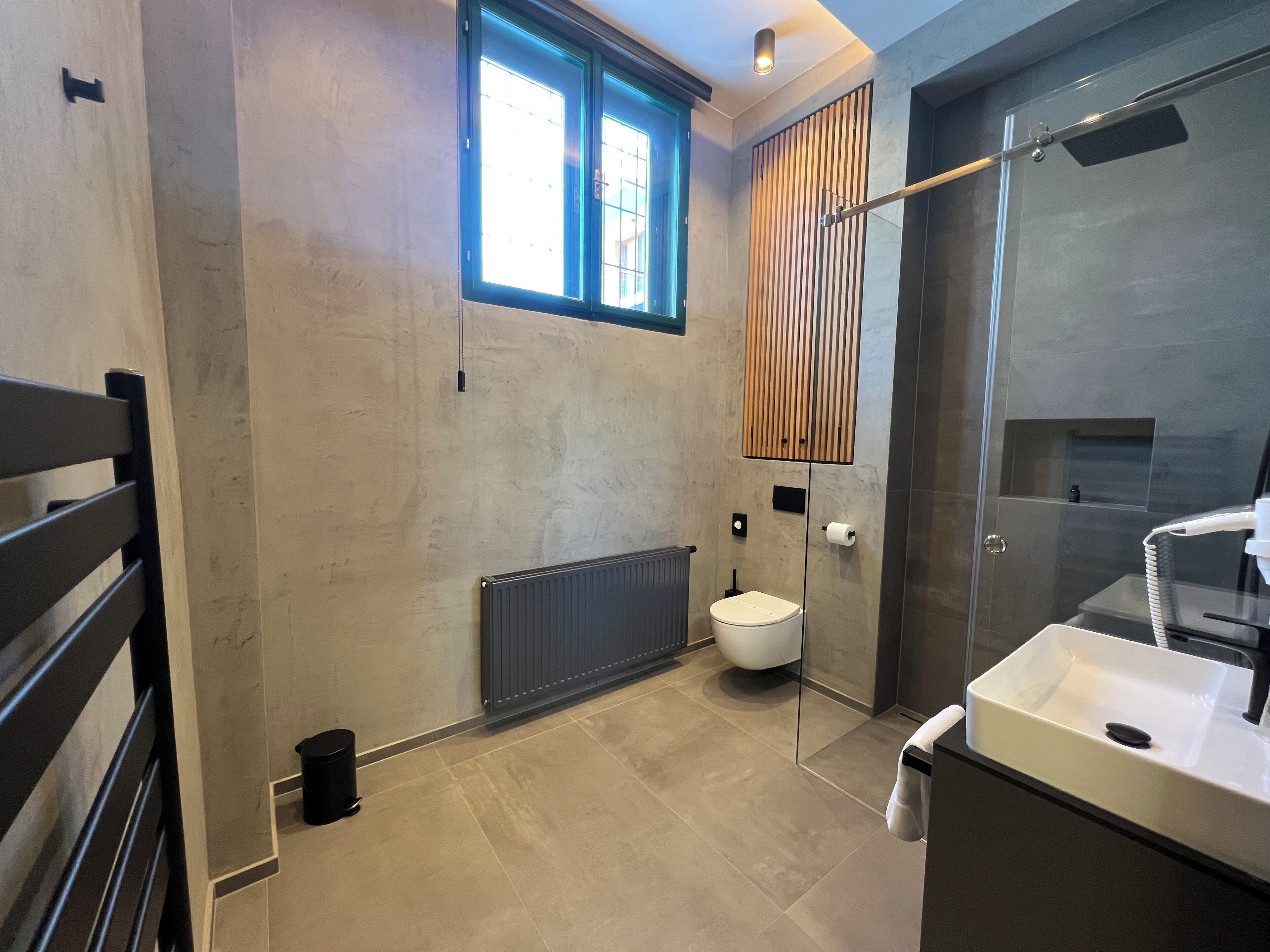 A modern bathroom with a toilet, sink, and shower.