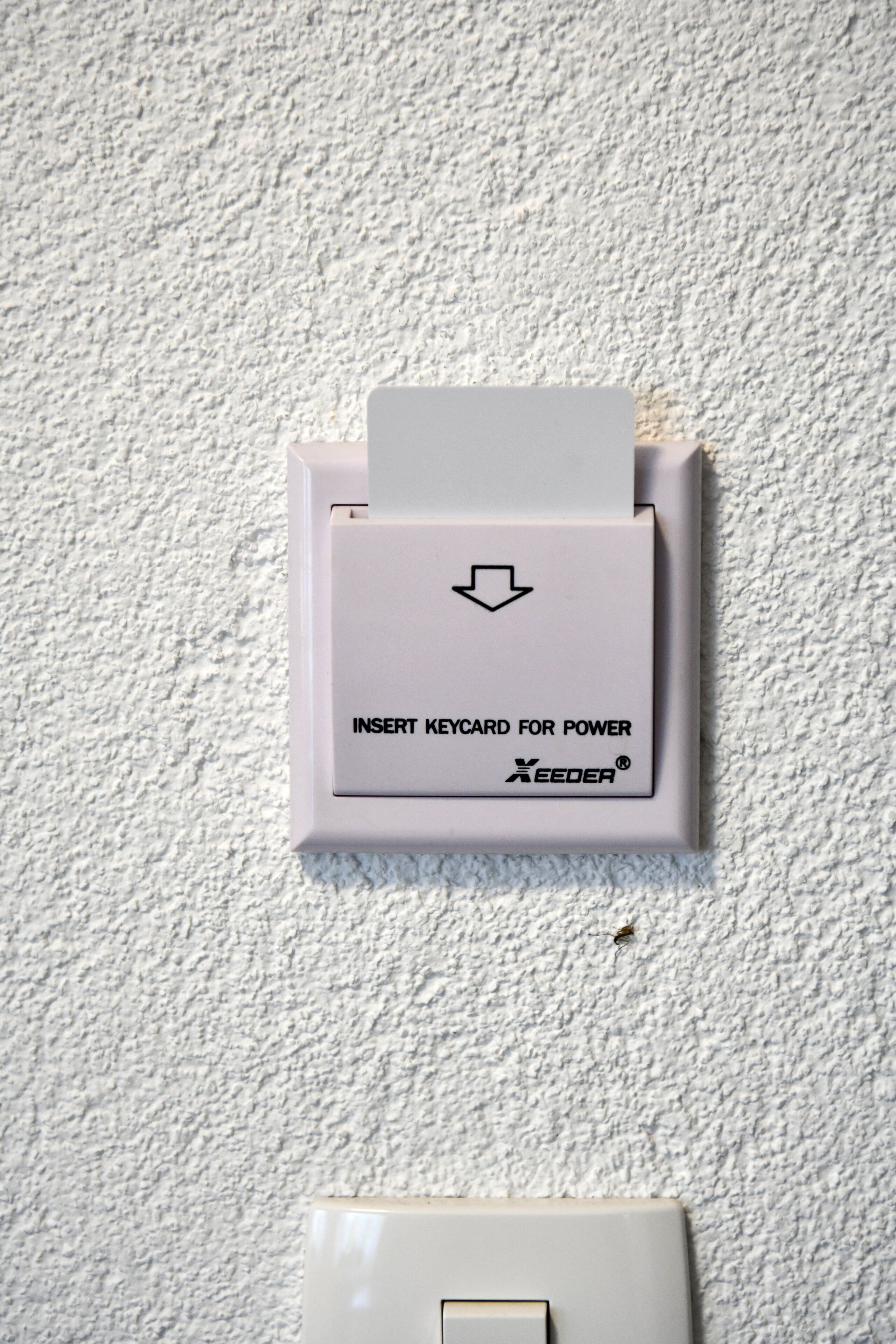 Eine wandmontierte Steckdose mit einem Hinweis, eine Chipkarte für Strom einzulegen.