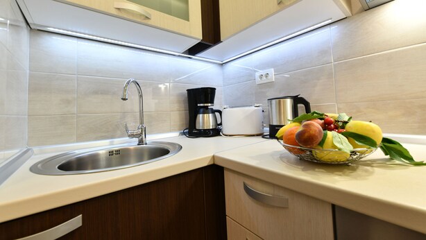 A modern kitchen with a stainless steel sink, a coffee maker, and a fruit bowl on the counter. - House Jelena (Rakovica)