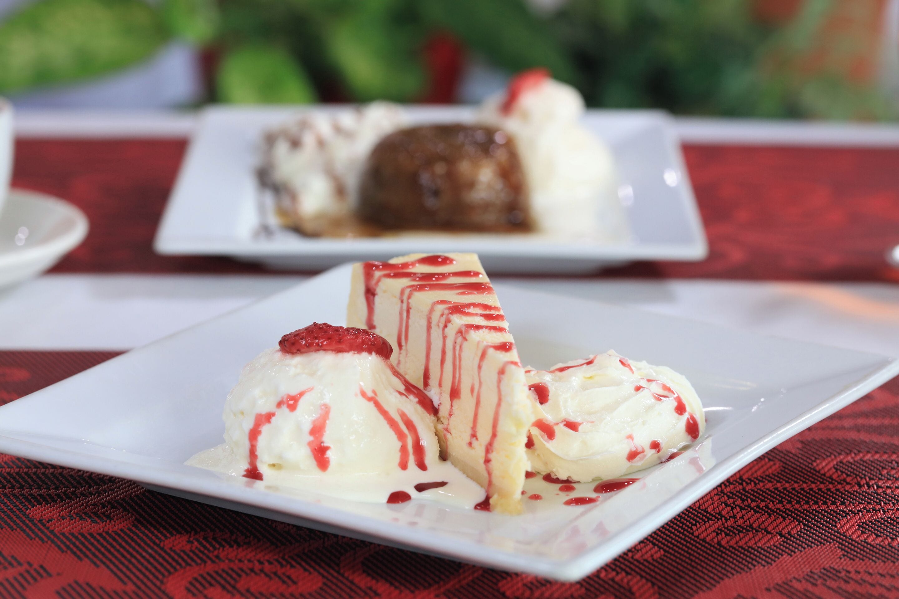 Un plato de postre con helado y un trozo de pastel sobre una mesa.