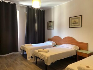 A hotel room with two single beds, a wooden headboard, a nightstand, and a framed picture on the wall. - Hotel Galla (Milan)
