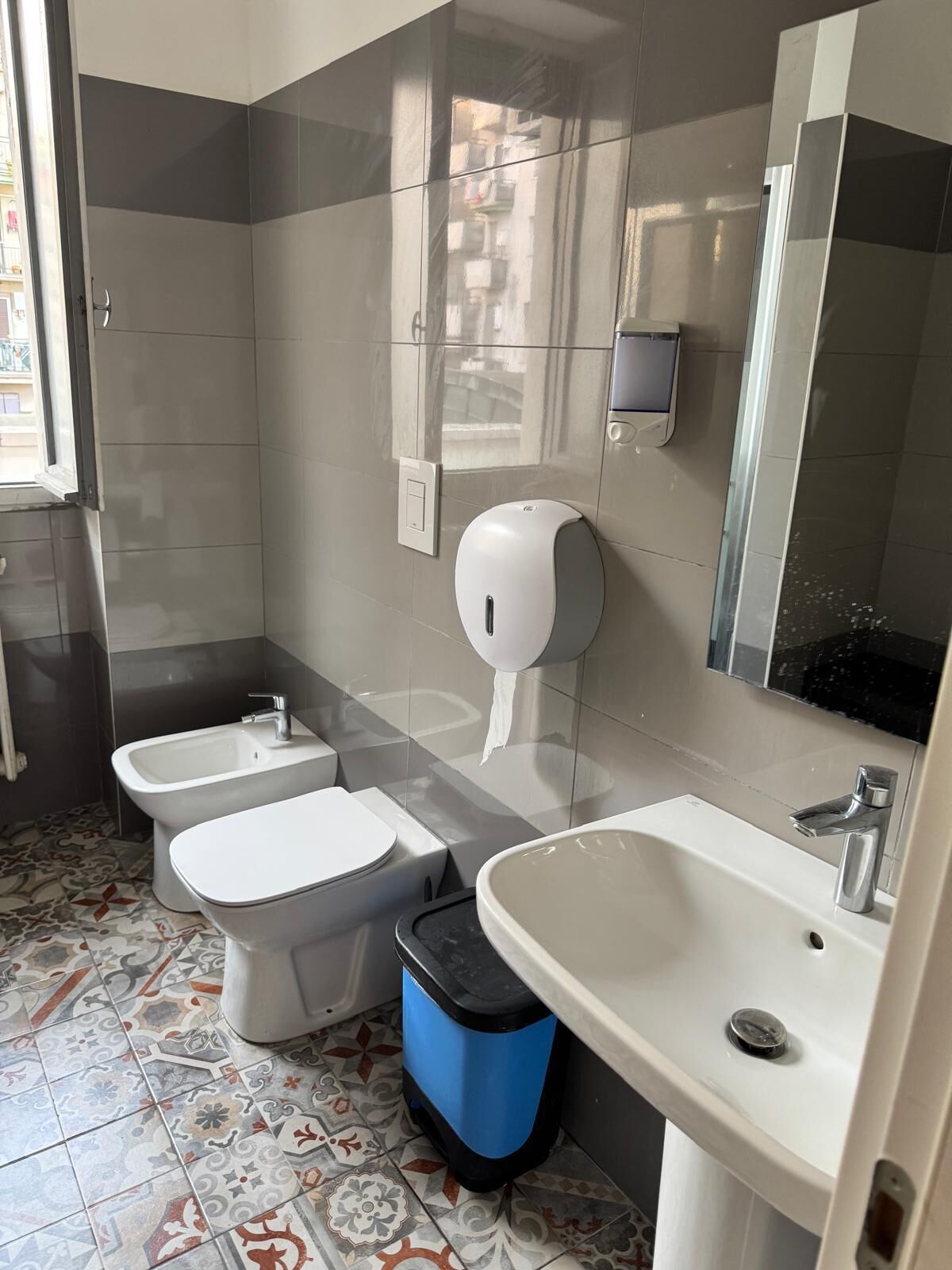 Un bagno con due servizi igienici, un bidet, un lavandino e un cestino.