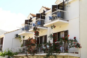 A multi-story building with balconies, some with metal railings and others with wooden shutters. - Villa Anka (Konavle)