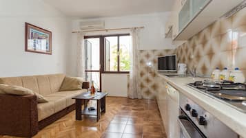 Departamento superior, 1 habitación, balcón, vista al jardín | Área de sala de estar | Televisión LCD