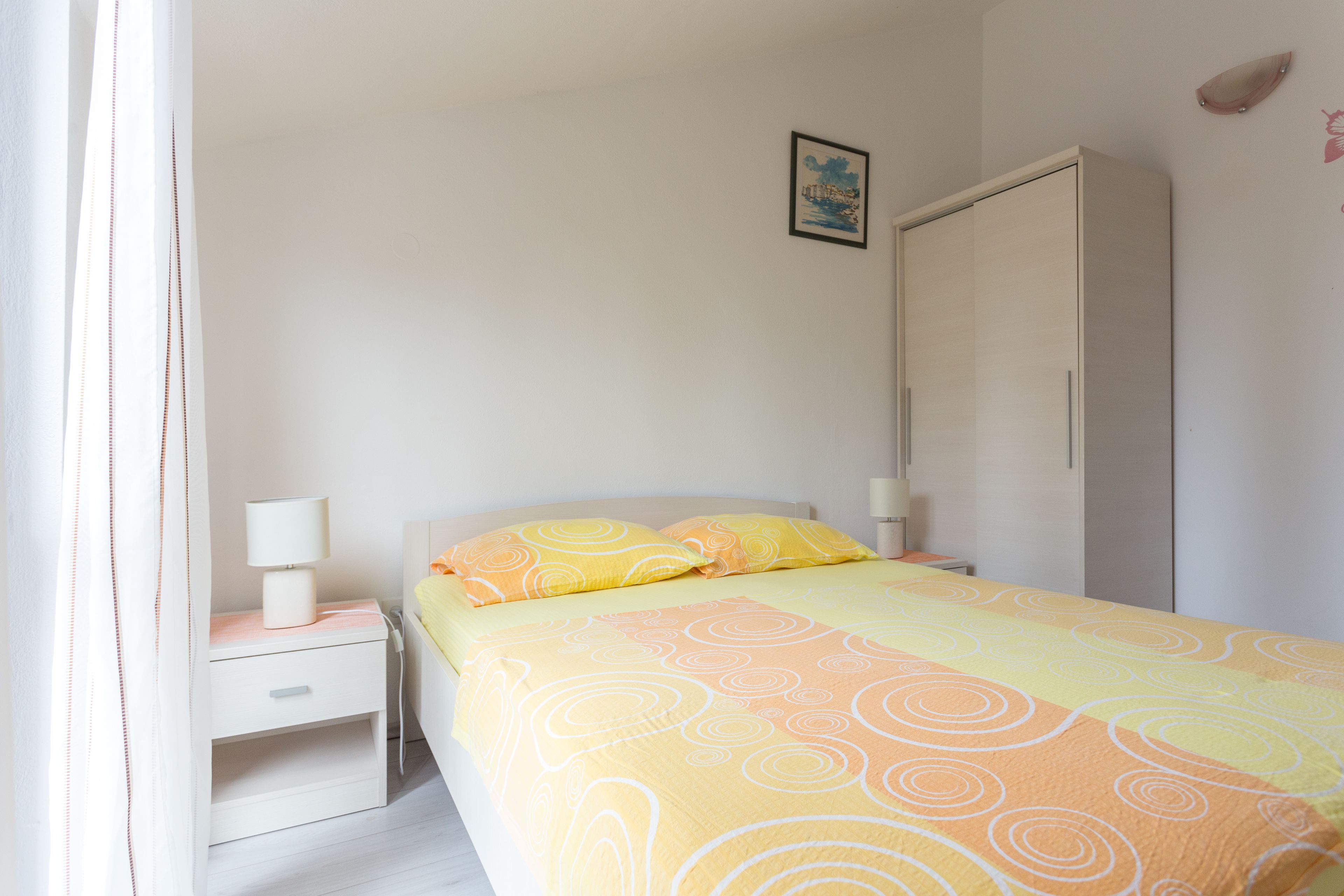 Ein Schlafzimmer mit Bett, Nachttisch und Kleiderschrank.