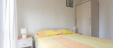 Ein Schlafzimmer mit Bett, Nachttisch und Kleiderschrank.