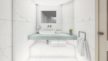 Un baño moderno con tocador de mármol, un lavamanos, un espejo y un perchero para toallas.