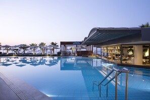 A pool area with a bar and lounge chairs. - Thalassa Beach Resort - Adults Only (Chania)