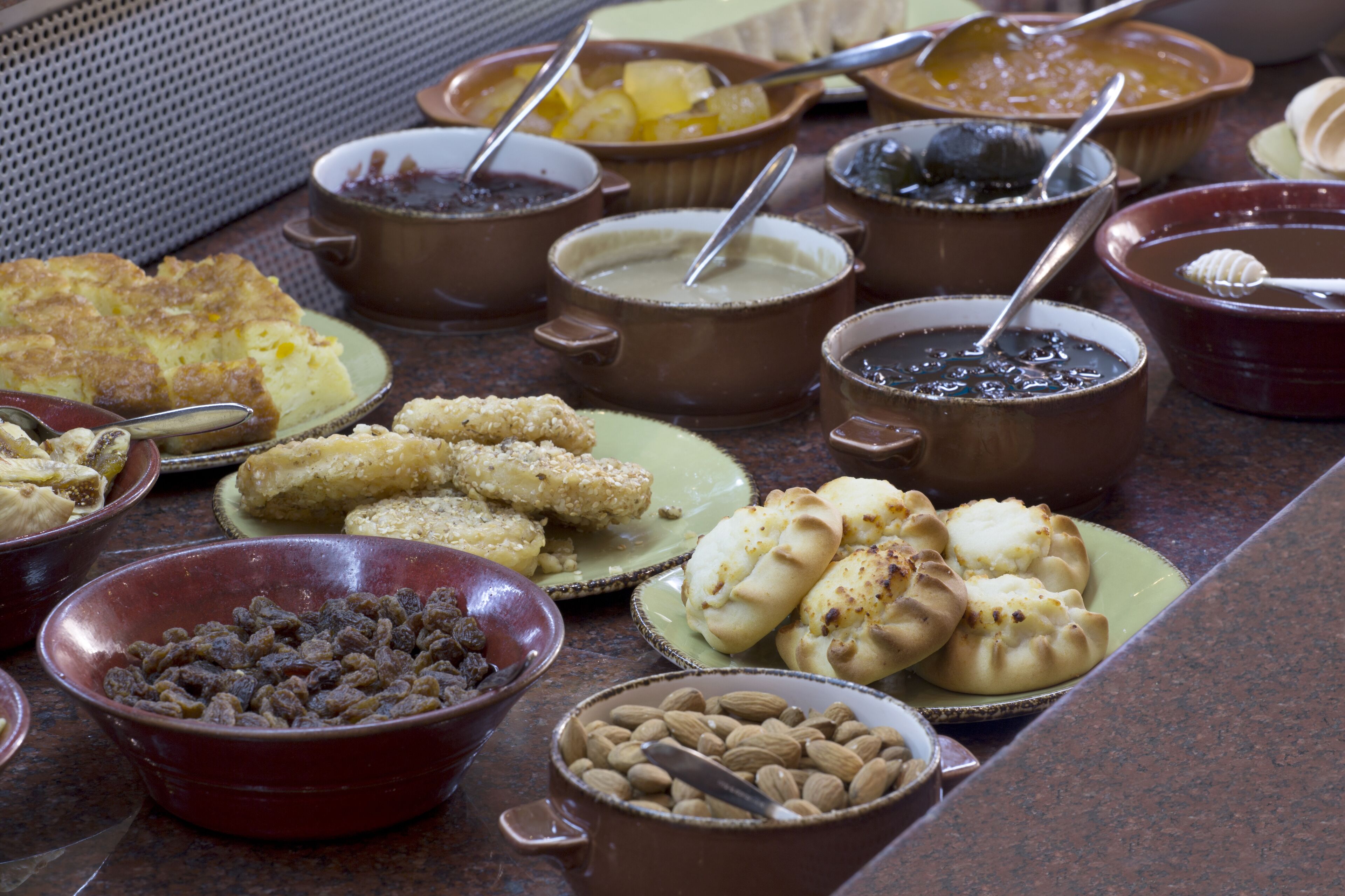 A buffet table with various food items and bowls.