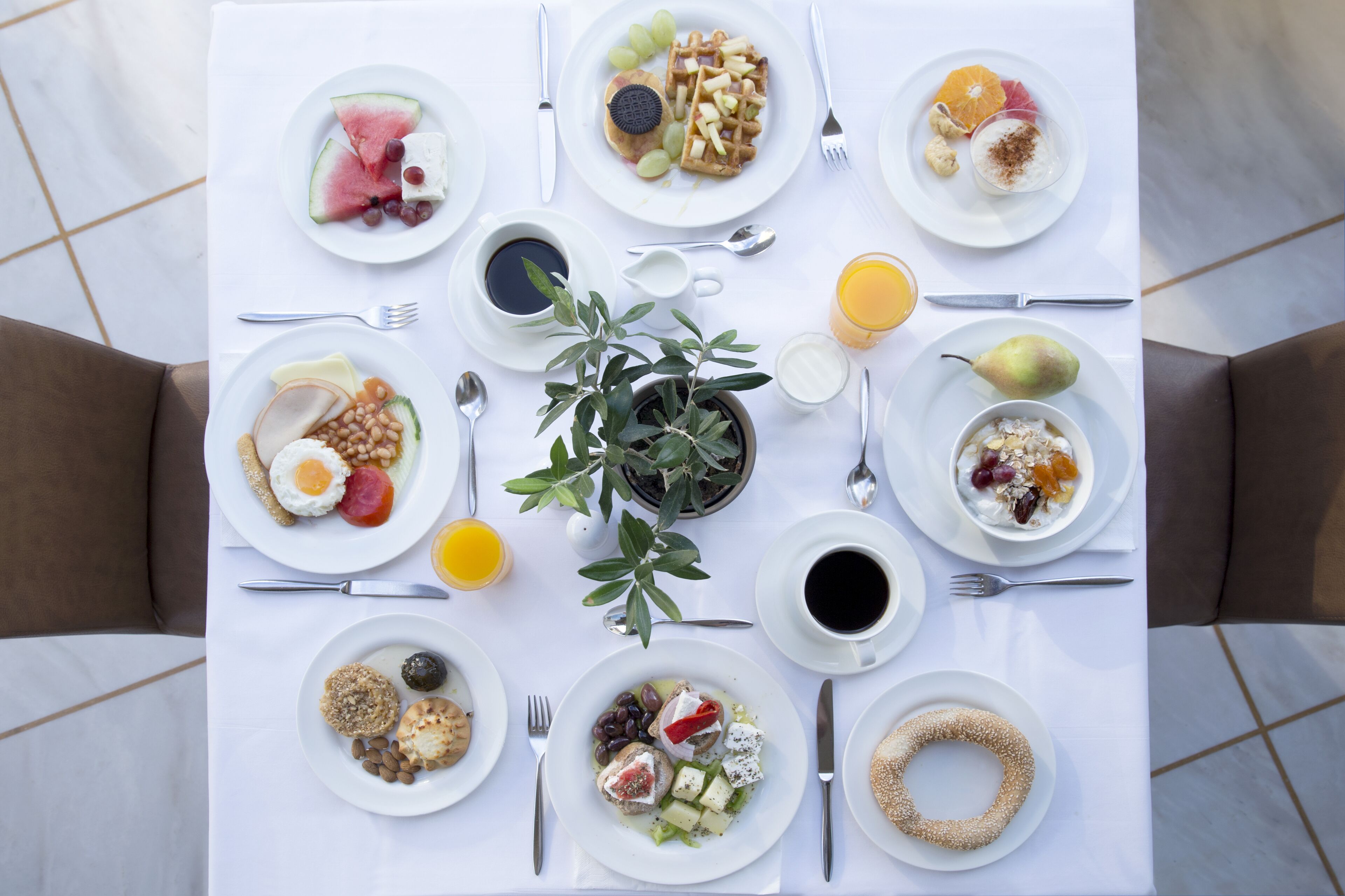 A breakfast table with various dishes, including eggs, toast, and fruit.