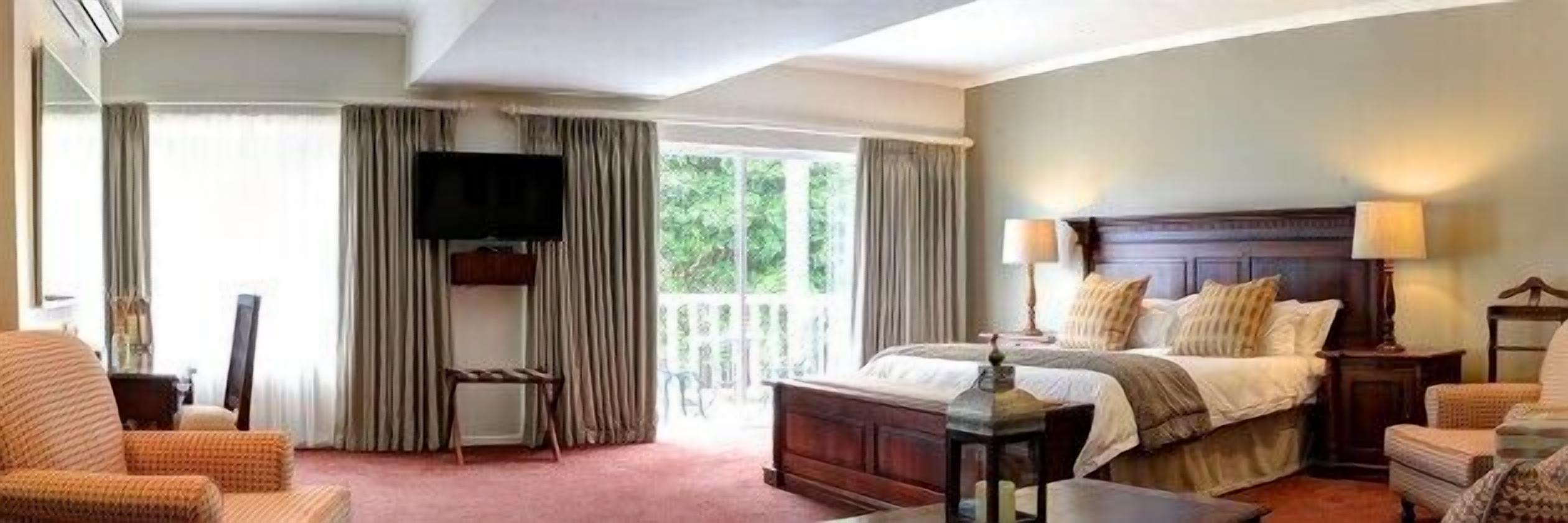 Une chambre d’hôtel avec un grand lit, un téléviseur fixé au mur, un bureau et une chaise.