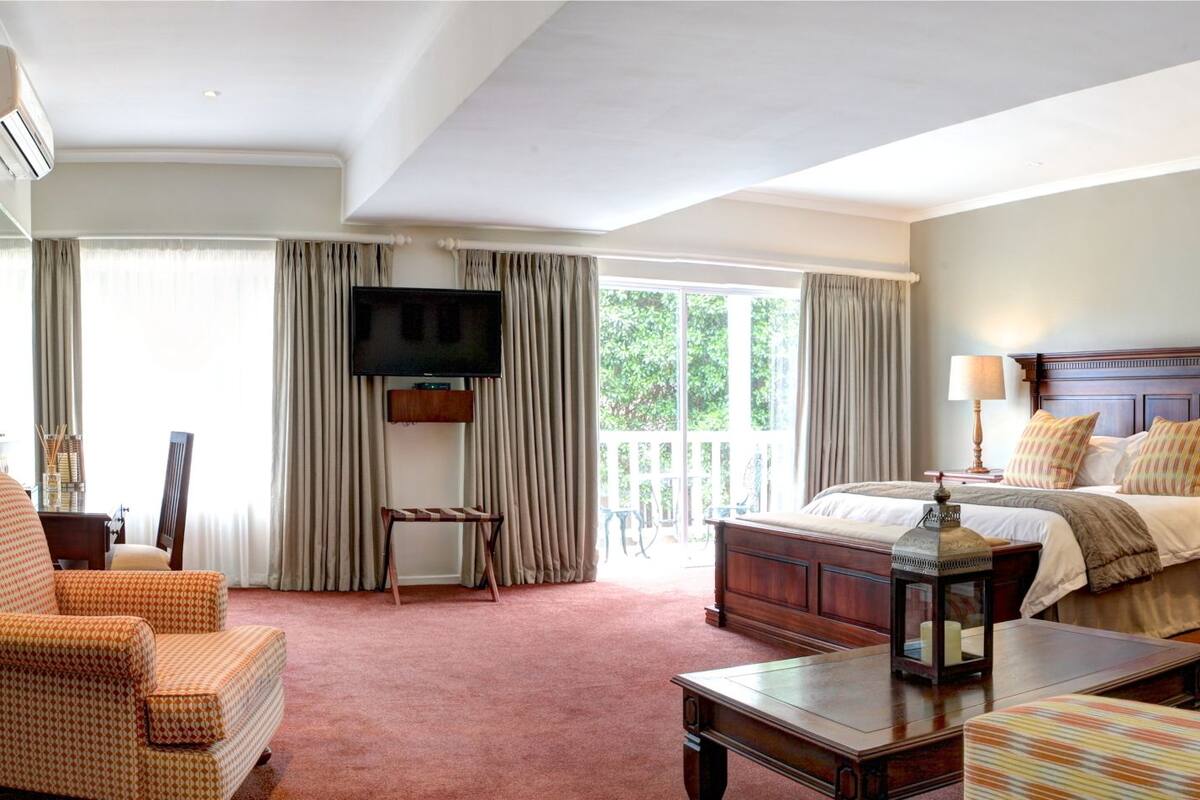Ett hotellrum med en stor säng, en TV, ett skrivbord och en stol.