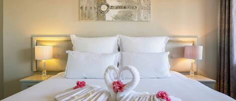 A hotel room with a large bed, two nightstands, and a wall art piece above the bed.