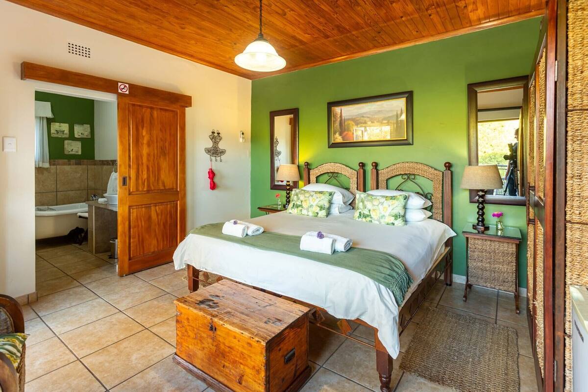 A bedroom with a wooden bed, green walls, and a wooden chest.