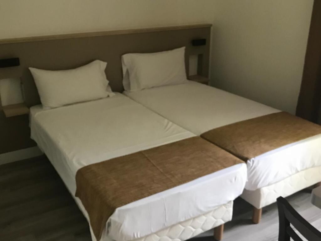 A double bed with a wooden headboard and two pillows.