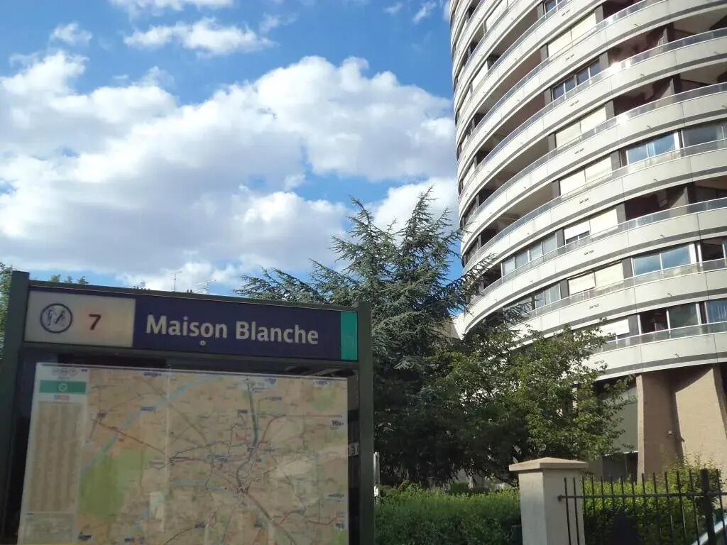 A bus stop sign with 'Maison Blanche' and a map.