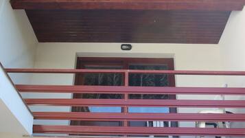 Un balcon doté d’un plafond en bois et d’une rambarde en métal.