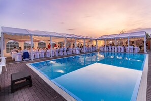 A poolside event with a covered area and tables, surrounded by a pool. - Aranyhordó Panzió Étterem és Pizzéria (Pere)