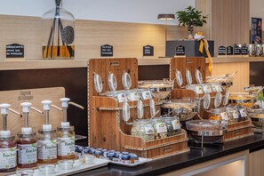 Buffet-pöytä, jossa on tarjolla monipuolinen valikoima ruokia ja erilaisia mausteita.