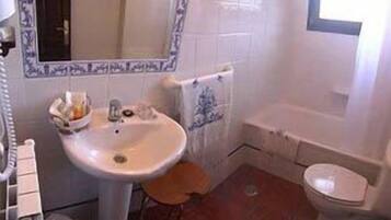 Un bagno con lavandino, specchio e WC.