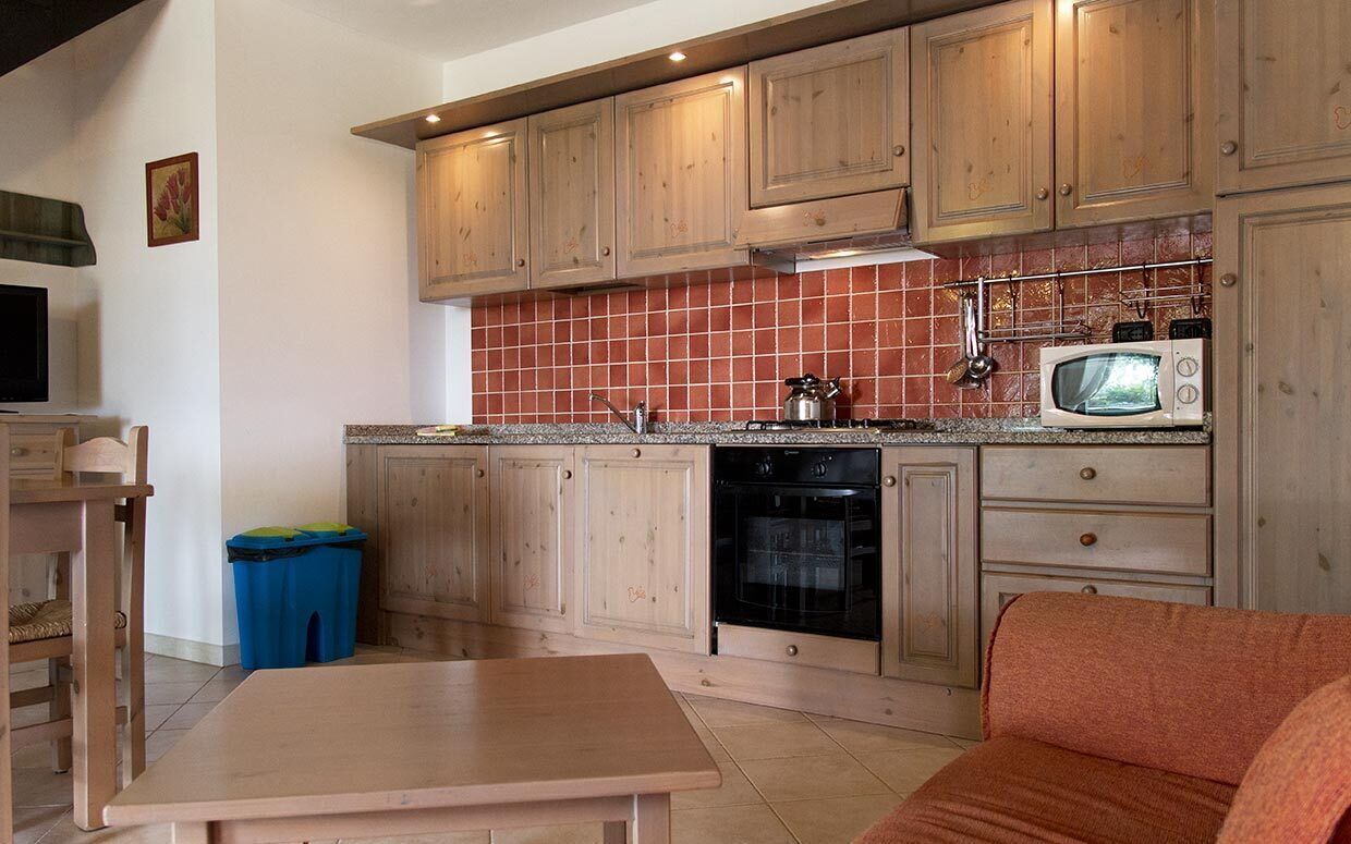 Una cocina con armarios de madera, un microondas y una estufa.