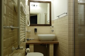 A bathroom with a white sink, a mirror, a toilet, and a shower area. - Navona Governo Vecchio (Rome)