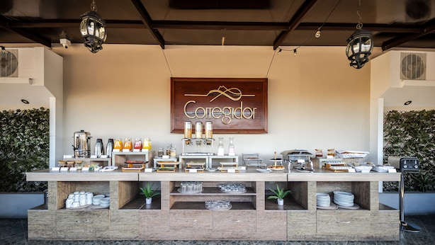 Ein Frühstücksbuffet mit einem Schild, auf dem 'Correedor' steht, mit verschiedenen Speisen und Getränken.