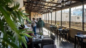 Ein Restaurant mit Außenbereich, Tischen, Stühlen und hängenden Laternen.