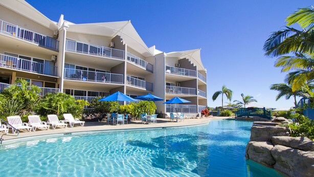 Ein Hotel mit Schwimmbad, mehreren Balkonen und Außenbereich-Sitzgelegenheiten.
