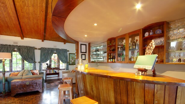 A wooden bar area with stools, a counter, and a display of a restaurant rating book.