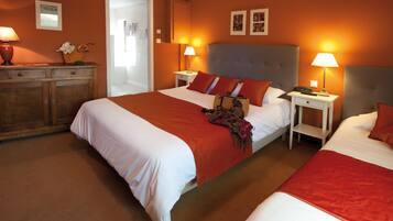 A hotel room with two beds, a wooden dresser, and two bedside tables with lamps.