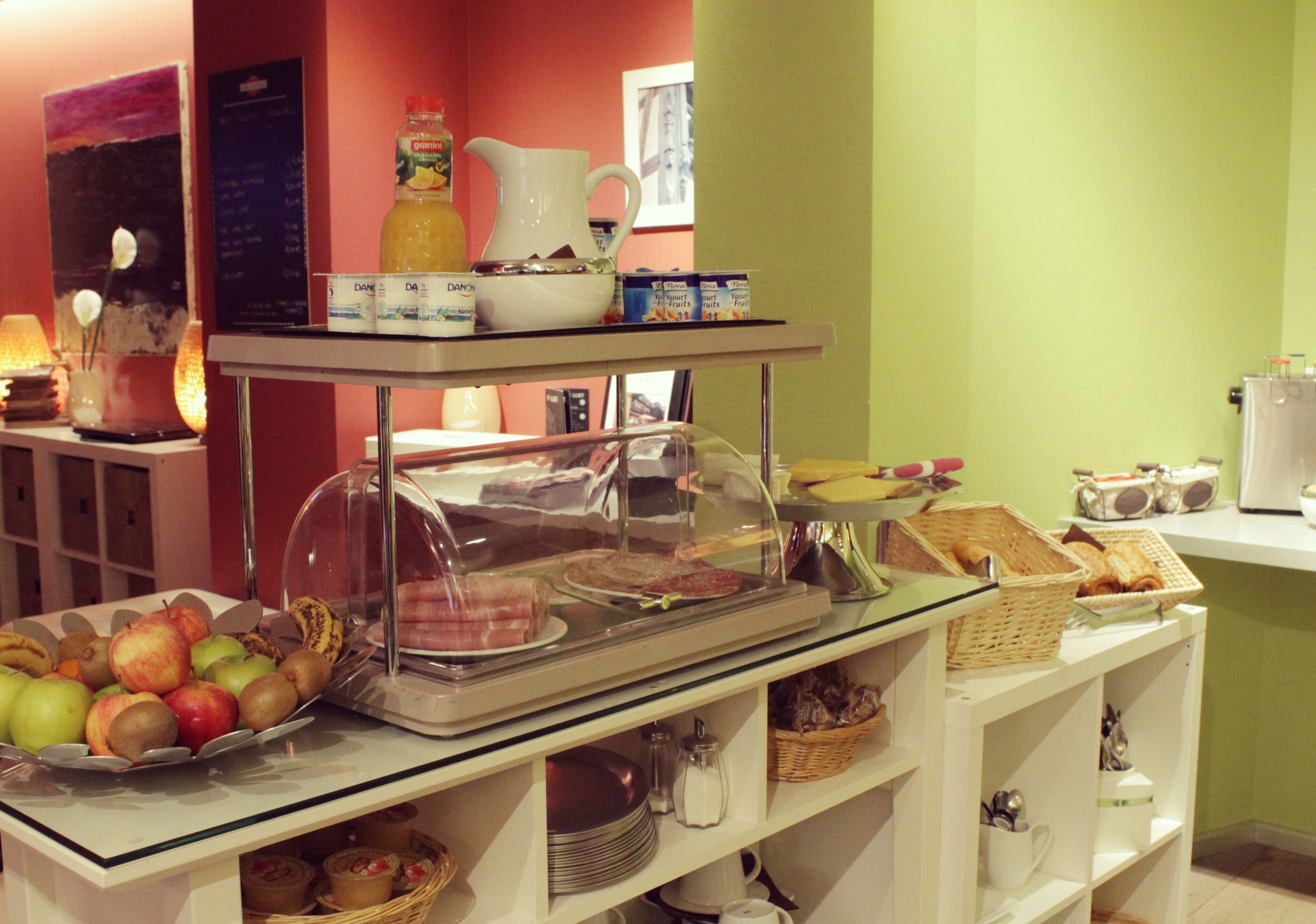 A buffet setup with a variety of food items, including fruits, pastries, and beverages.