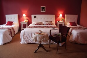 A hotel room with a large bed, two bedside tables with lamps, a small table with a bowl, and a chair. - Le Gouverneur (Obernai)