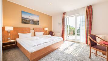 A modern hotel room with a large bed, two bedside tables with lamps, a chair, and a view of the outdoors through a sliding glass door.