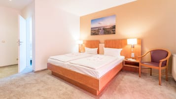 Un dormitorio con una cama de madera, dos mesitas de noche, una silla y un cuadro en la pared.