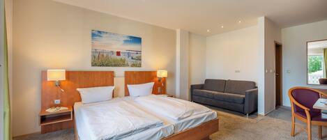 Una habitación de hotel moderna con una cama grande, un sofá y una silla.