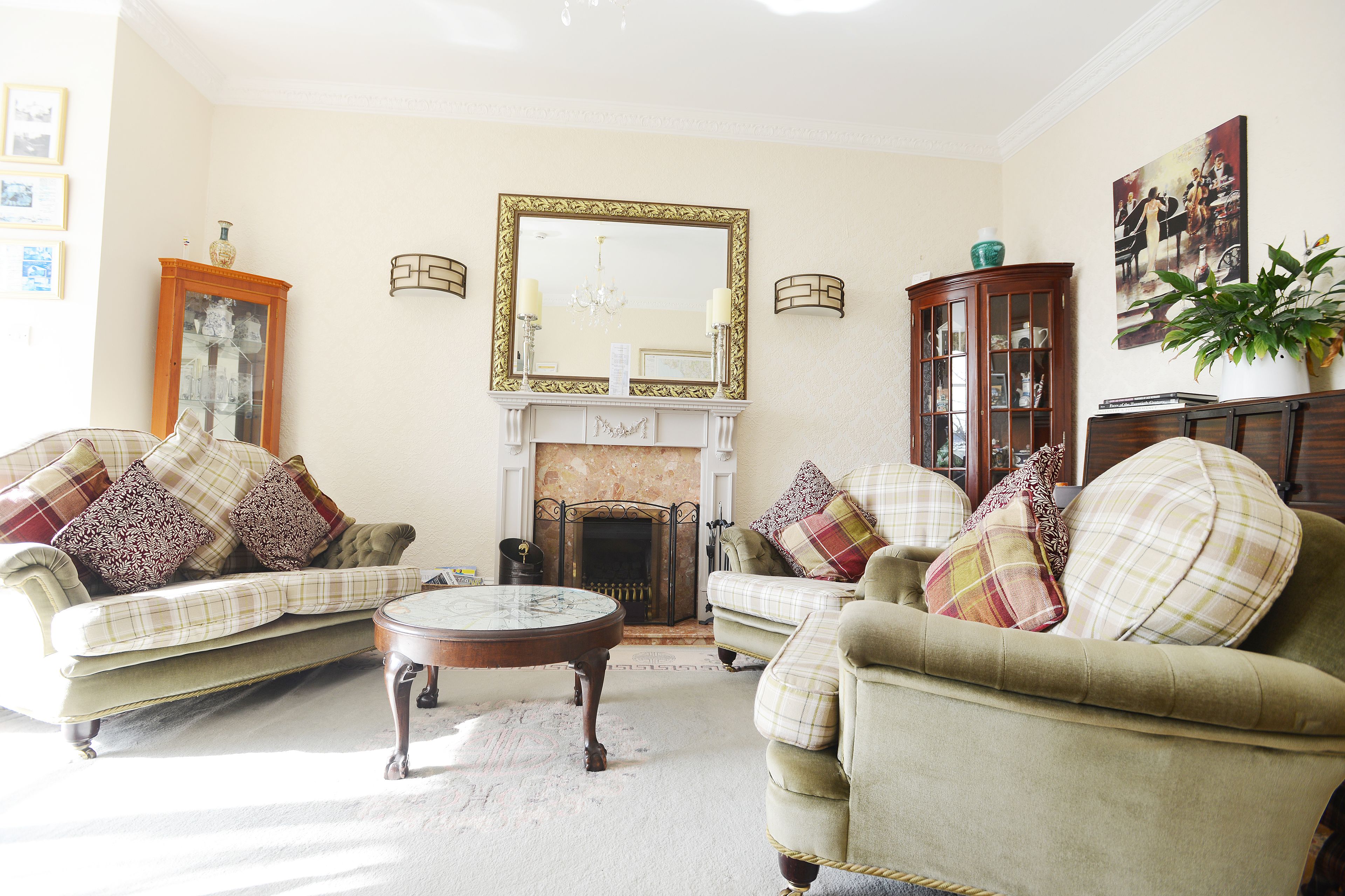 A living room with two sofas, a fireplace, and a large mirror.