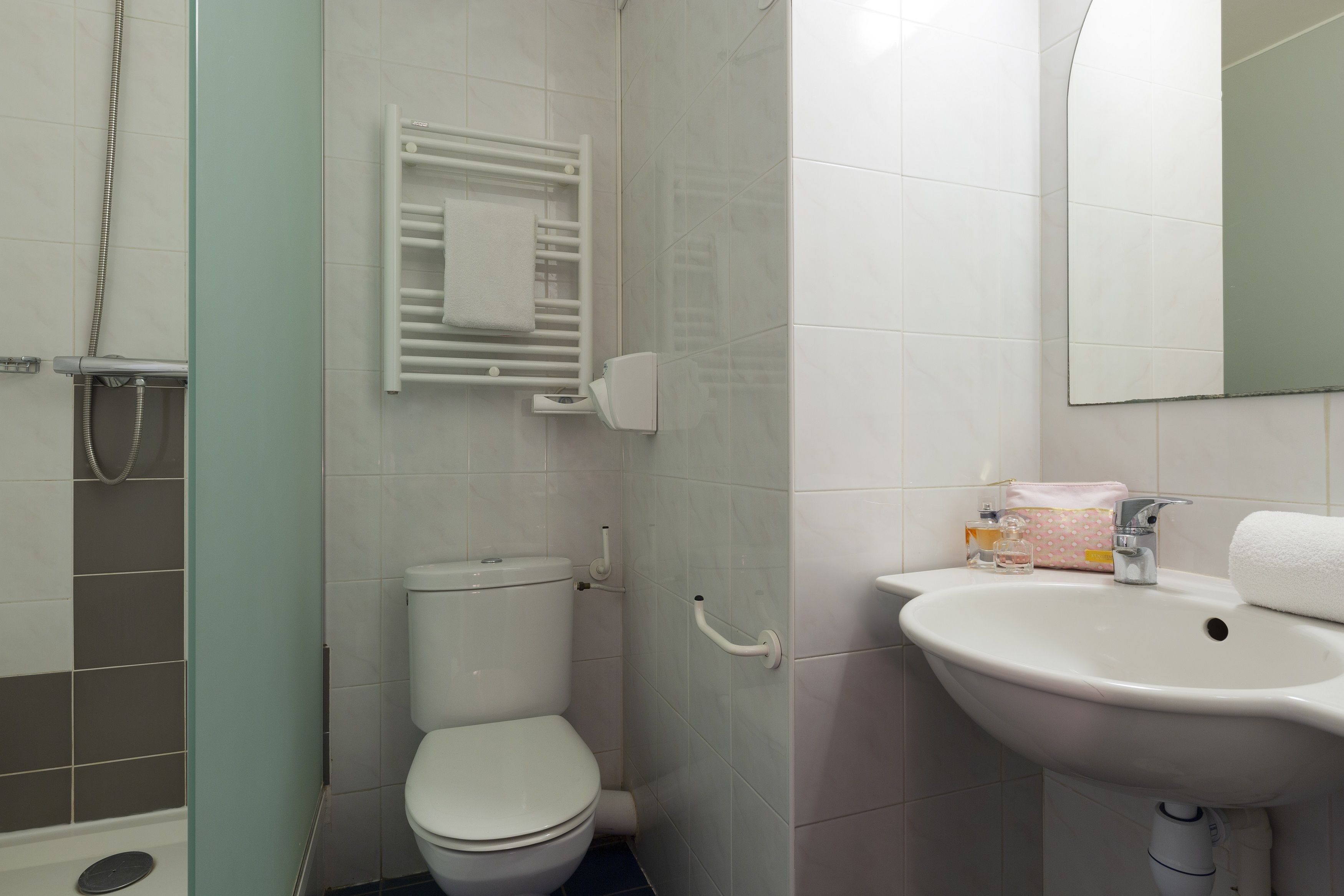 Une salle de bain avec des toilettes, un lavabo et une douche.