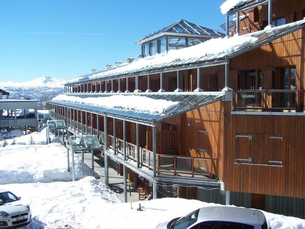 A wooden building with a covered walkway and a glass-roofed upper section.