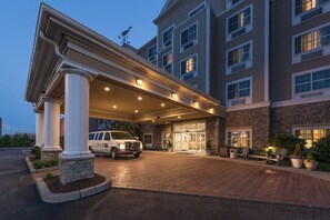A hotel entrance with a covered driveway, a white van parked in front, and a stone building facade. - Fairfield Inn & Suites by Marriott New Bedford (New Bedford)