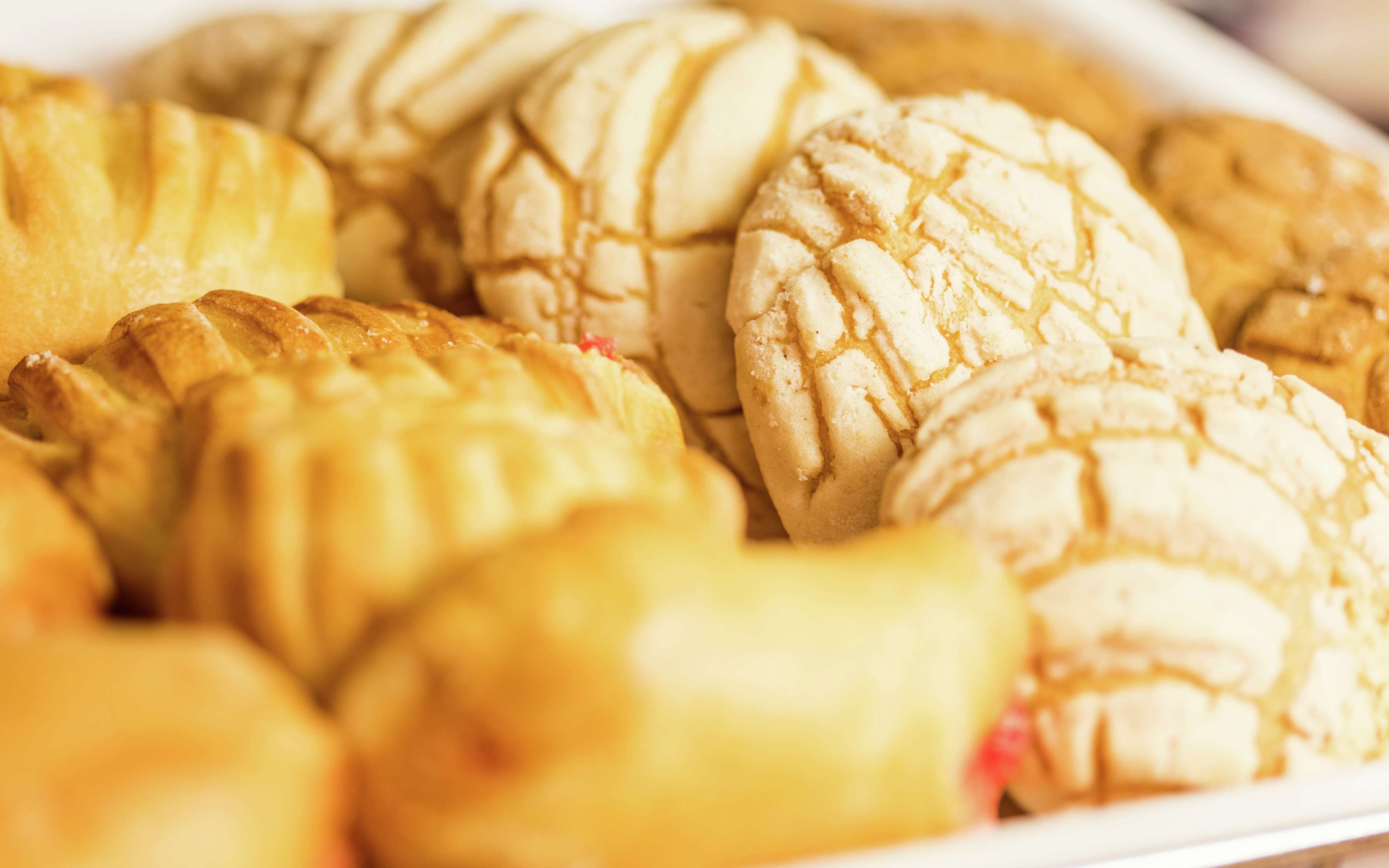 Diversos pastéis, incluindo tortas e biscoitos, dispostos sobre um prato.