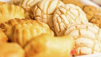 Diversos pastéis, incluindo tortas e biscoitos, dispostos sobre um prato.