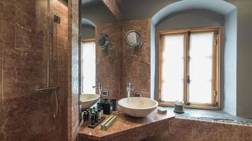 Een badkamer met een groot wastafel, douche en raam.