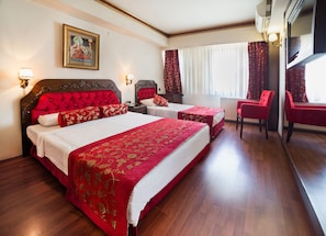 A hotel room with two beds, a sitting area with a red chair, and a large mirror. - Hotel Santa Pera (Istanbul)
